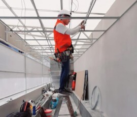 Personal de ingeniería de M2 Arquitectos realizando el montaje de estructura metálica para techo industrial, utilizando equipo de seguridad y líneas de vida.