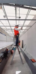 Personal de ingeniería de M2 Arquitectos realizando el montaje de estructura metálica para techo industrial, utilizando equipo de seguridad y líneas de vida.