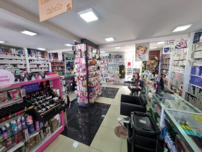 Interior de tienda mayorista de productos de belleza diseñada por M2 Arquitectos, con amplios pasillos, exhibidores organizados, iluminación LED brillante y piso de porcelanato negro pulido.