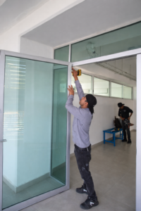 Instalación de puertas de vidrio y canceles en oficina por técnico especializado.