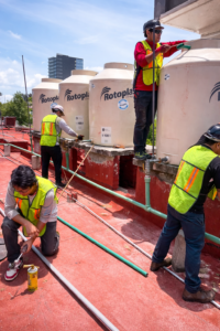 Personal de M2 Arquitectos realizando trabajos de plomería e instalación de tinacos.